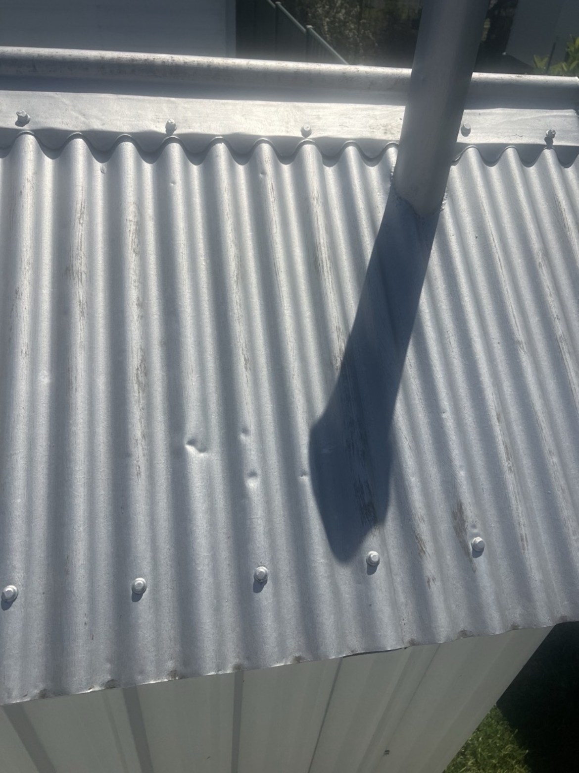 Real corrugated metal roof photo showing hail dents, used for the interactive demo